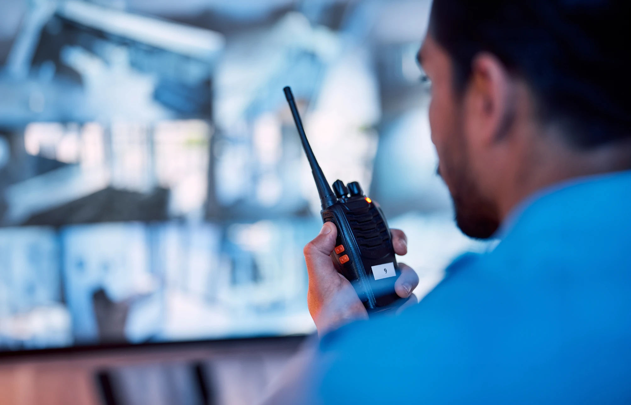 Policier en uniforme portant une casquette réglementaire, les bras croisés dans une posture d'autorité et de surveillance professionnelle