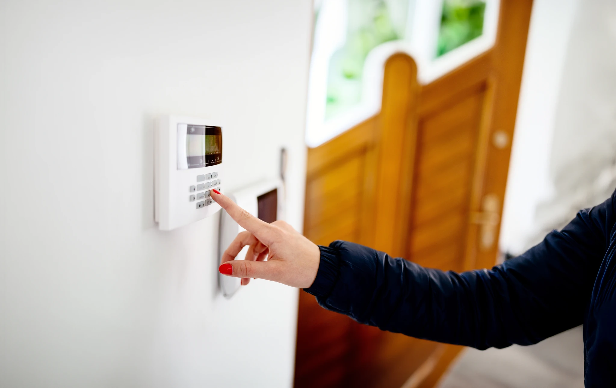 Sonnette d'entrée dans un immeuble à appartements multiples, avec caméra de surveillance vidéo, sur un mur sombre