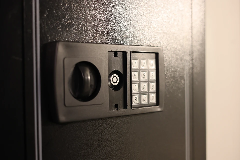 Homme d'affaires souriant au téléphone dans un entrepôt de commerce électronique, assis à un bureau avec ordinateur portable ouvert